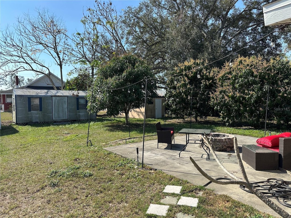 view of yard with a storage shed, a patio area, and an outdoor fire pit