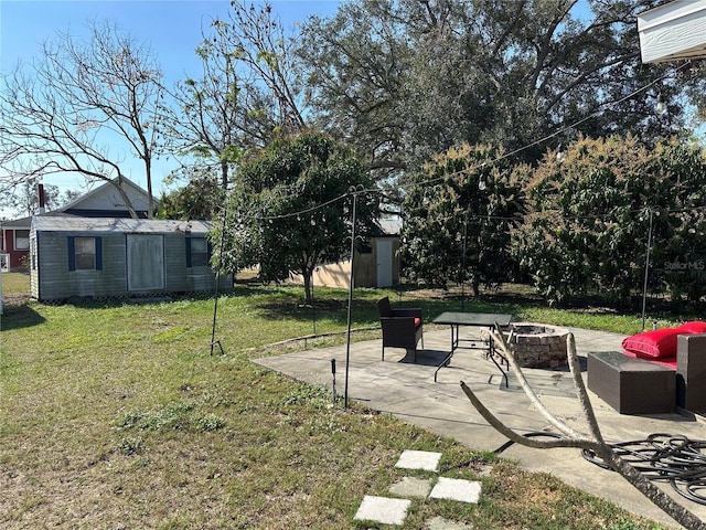 view of yard with a storage shed, a patio area, and an outdoor fire pit