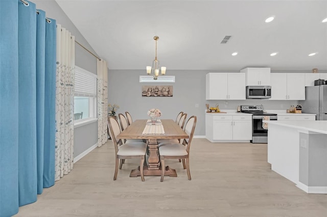 dining room with an inviting chandelier and light hardwood / wood-style floors