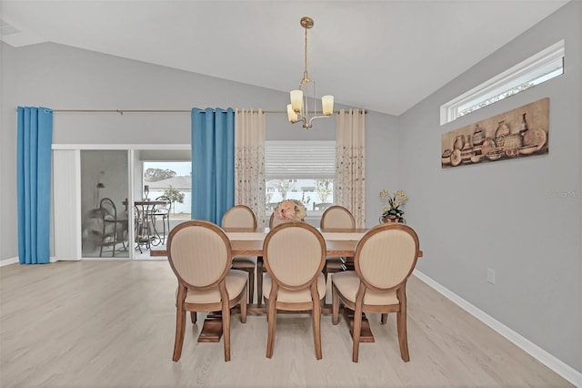 dining space featuring lofted ceiling, a chandelier, and light hardwood / wood-style floors