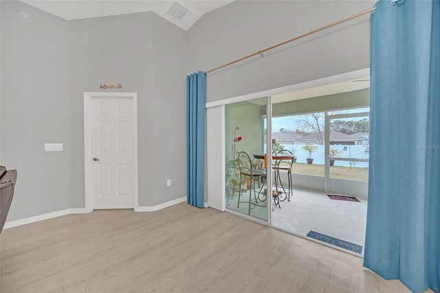 empty room with vaulted ceiling and hardwood / wood-style floors