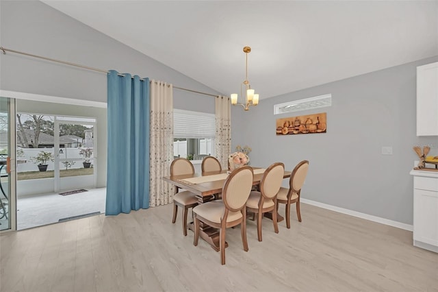 dining area featuring vaulted ceiling, light wood-type flooring, and a chandelier