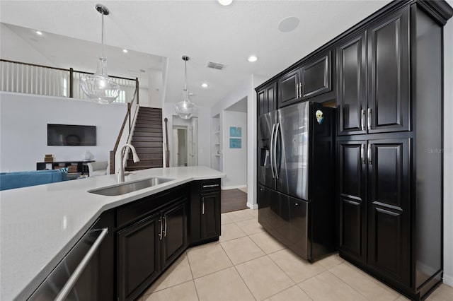 kitchen featuring light tile patterned flooring, appliances with stainless steel finishes, sink, and decorative light fixtures