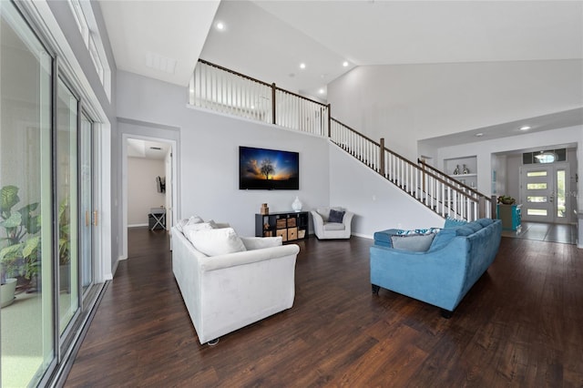 living room featuring dark wood-type flooring and high vaulted ceiling