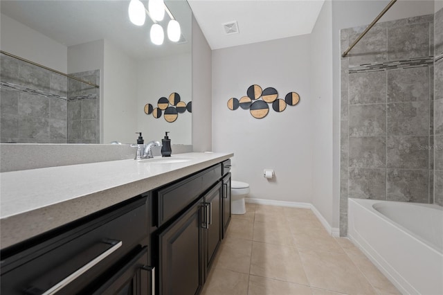 full bathroom with tile patterned flooring, vanity, tiled shower / bath, and toilet