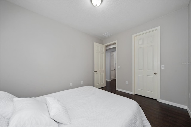 bedroom featuring dark wood-type flooring and a textured ceiling