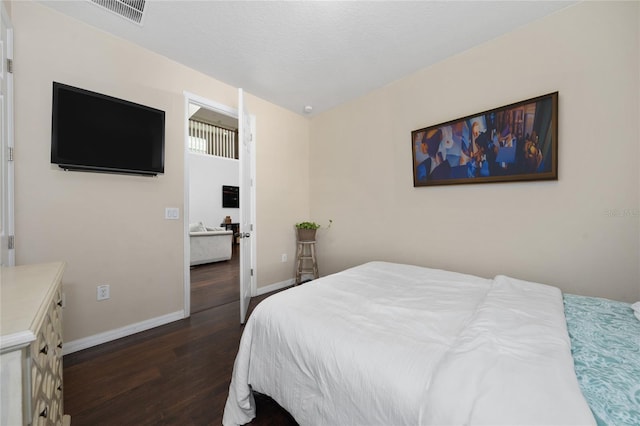 bedroom with dark wood-type flooring and a textured ceiling