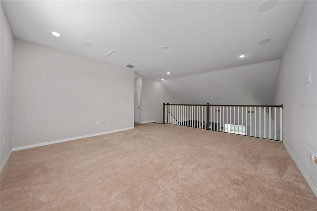 carpeted spare room with vaulted ceiling