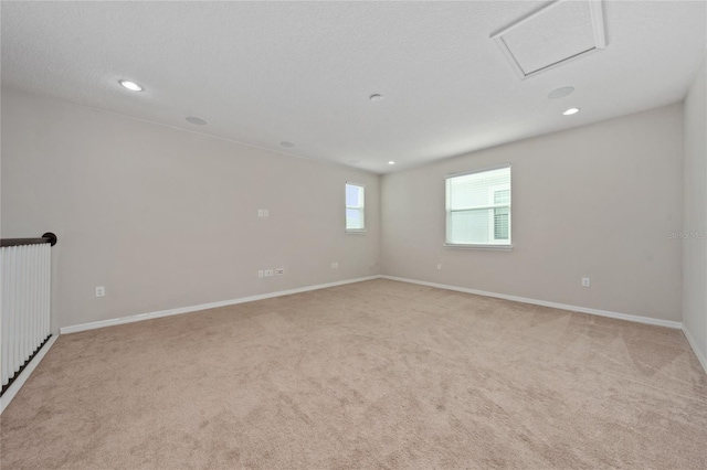 empty room featuring light carpet and a textured ceiling