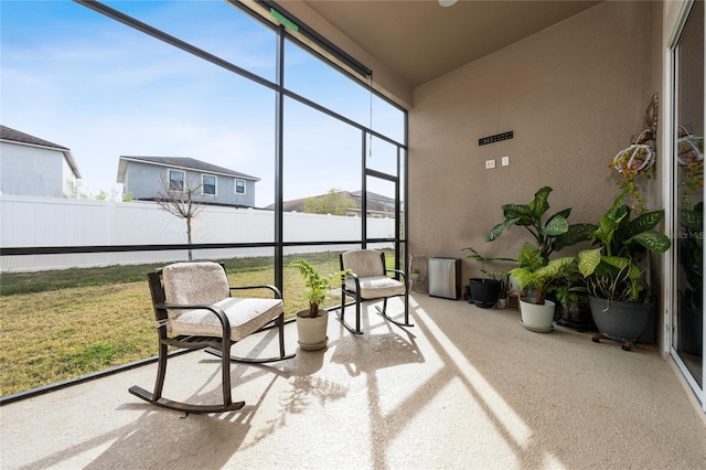 sunroom featuring a water view