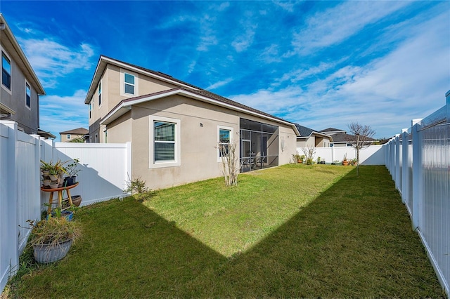 back of house with a yard and a sunroom