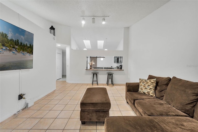 living room with light tile patterned flooring, track lighting, lofted ceiling, and a textured ceiling