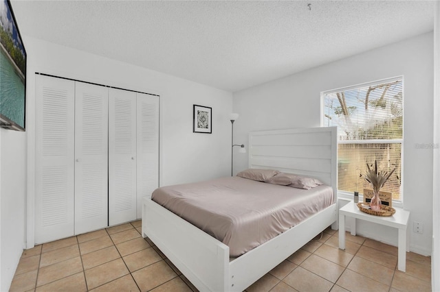 tiled bedroom featuring a textured ceiling and a closet