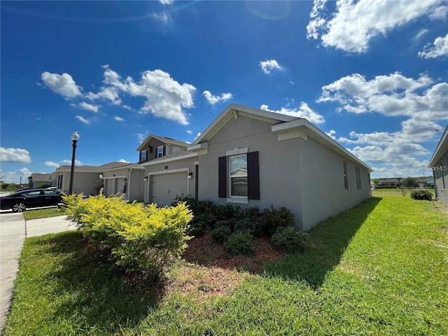 view of side of property with a garage and a lawn