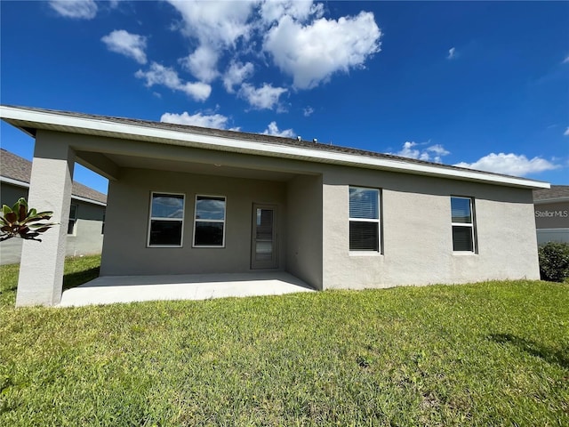 rear view of house featuring a yard and a patio