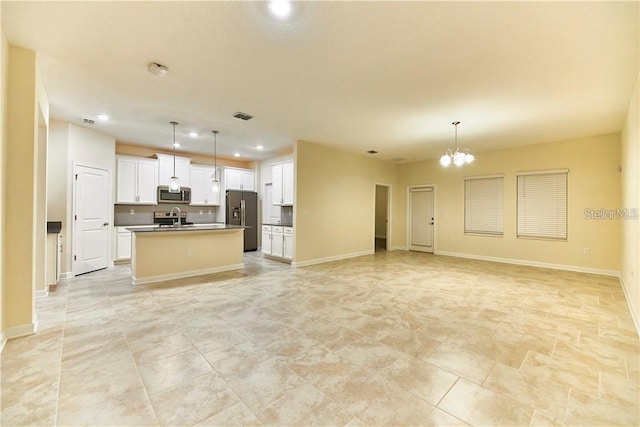 kitchen with appliances with stainless steel finishes, a kitchen island with sink, pendant lighting, and sink