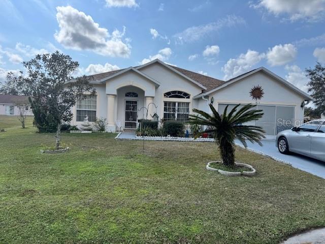 ranch-style home with a garage and a front lawn