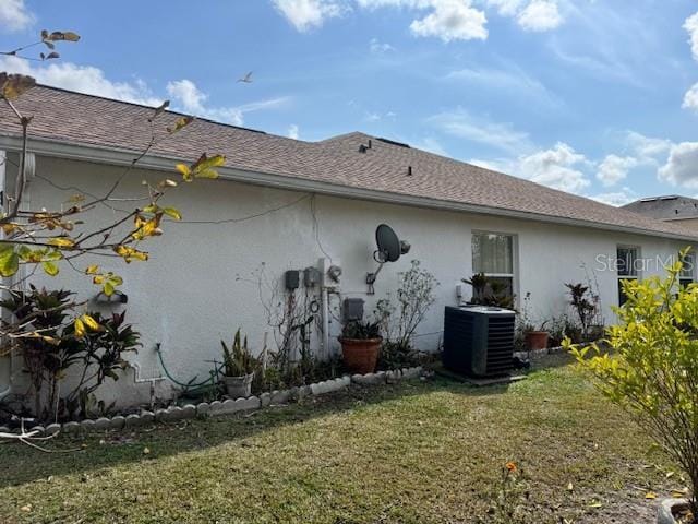 back of property with a lawn and central air condition unit