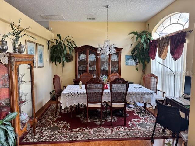 dining area featuring a textured ceiling and a chandelier