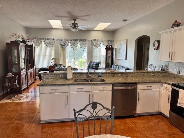 kitchen with dark stone countertops, sink, stainless steel appliances, and white cabinets