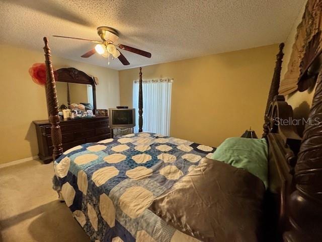 bedroom featuring carpet flooring, a textured ceiling, and ceiling fan