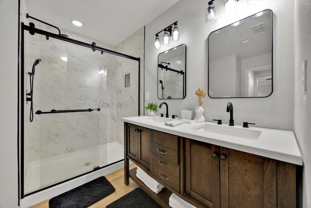 bathroom featuring a shower with door, vanity, and hardwood / wood-style floors