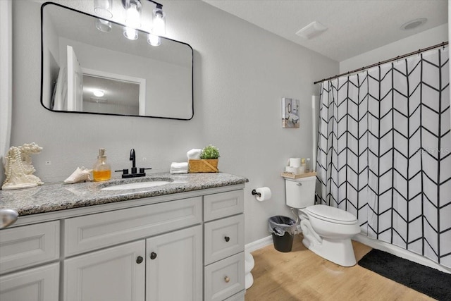 bathroom with walk in shower, vanity, toilet, and hardwood / wood-style floors