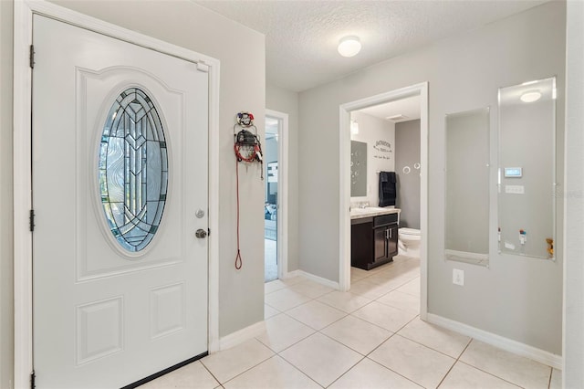 tiled entrance foyer featuring a textured ceiling