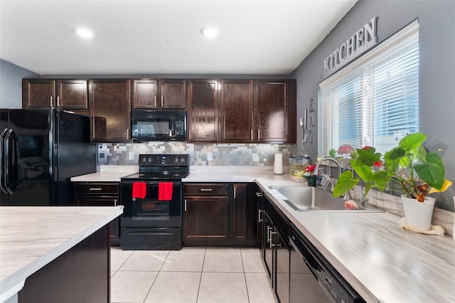 kitchen featuring tasteful backsplash, light tile patterned floors, sink, and black appliances