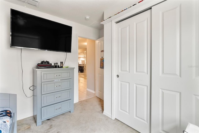 bedroom featuring light carpet and a closet