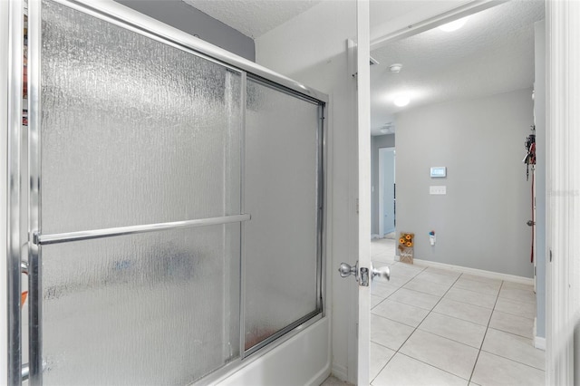 bathroom featuring tile patterned floors, a textured ceiling, and shower / bath combination with glass door