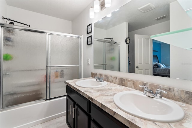 bathroom featuring tile patterned flooring, vanity, a textured ceiling, and combined bath / shower with glass door