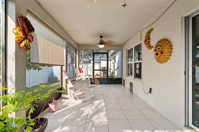 unfurnished sunroom featuring ceiling fan