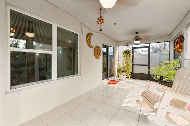 unfurnished sunroom with ceiling fan