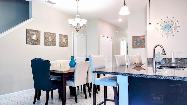 tiled dining space featuring sink and a notable chandelier