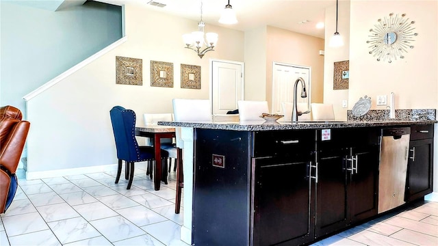 kitchen featuring sink, decorative light fixtures, a chandelier, and a kitchen bar