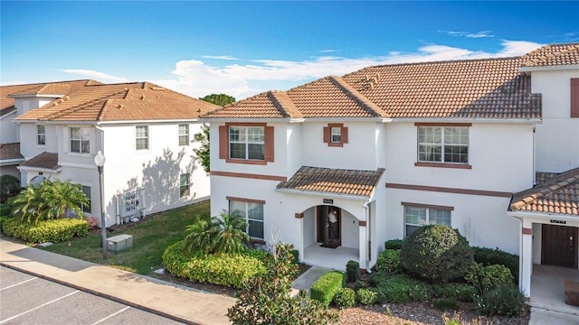 mediterranean / spanish home with stucco siding and a tiled roof