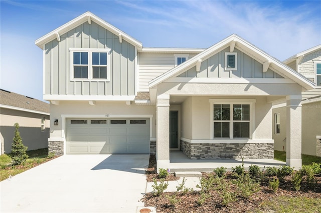 craftsman-style home featuring board and batten siding, stone siding, driveway, and a garage