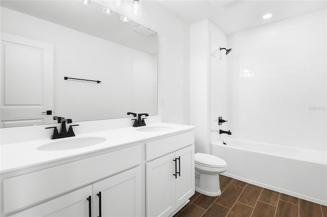 bathroom with double vanity, a sink, toilet, and wood tiled floor