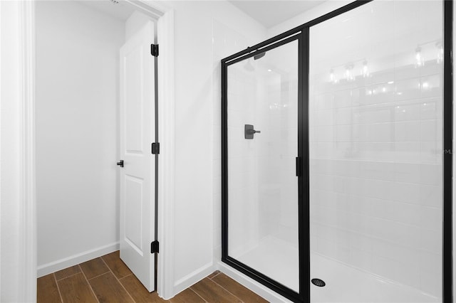 bathroom featuring a stall shower, wood finish floors, and baseboards