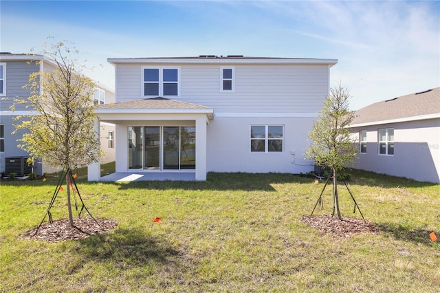 rear view of house featuring cooling unit, a lawn, and stucco siding