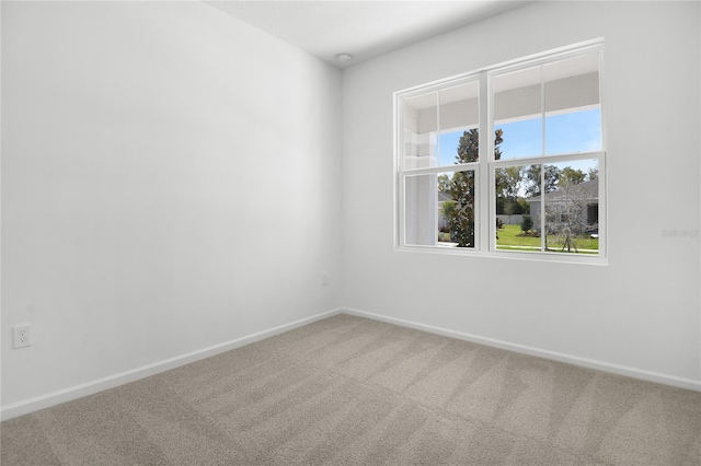 spare room featuring carpet and baseboards