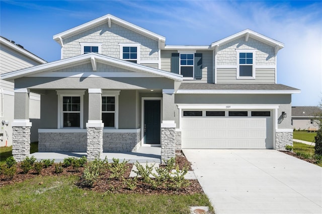 view of front of home with a porch, stone siding, an attached garage, and concrete driveway