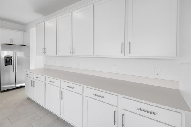 kitchen featuring light countertops, white cabinets, and stainless steel fridge with ice dispenser