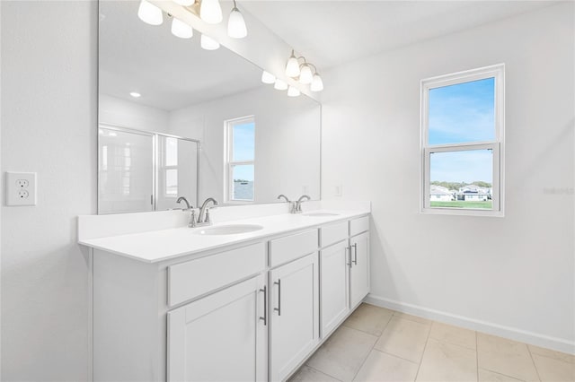 bathroom with baseboards, double vanity, a sink, and a shower stall