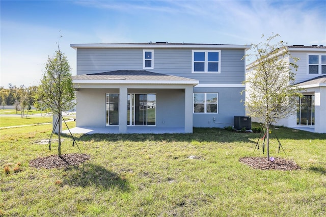 back of property with cooling unit, a lawn, and stucco siding