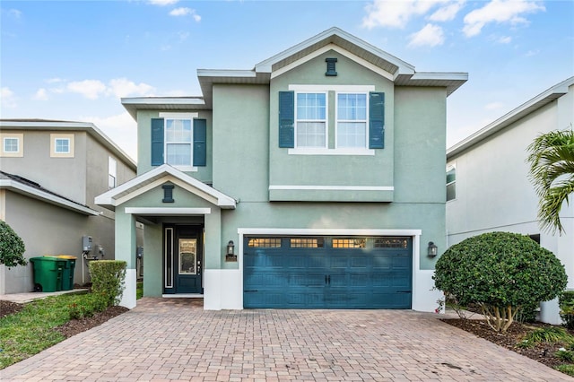 view of front of property with a garage, decorative driveway, and stucco siding