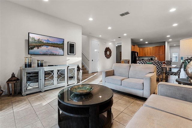 living area featuring light tile patterned floors, stairs, visible vents, and recessed lighting