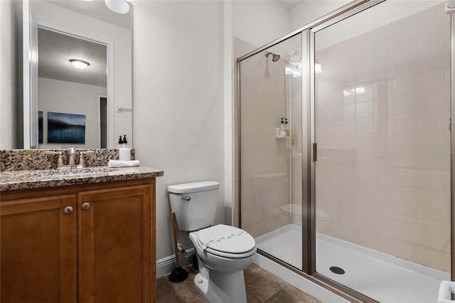 bathroom featuring toilet, a stall shower, a textured ceiling, vanity, and tile patterned flooring