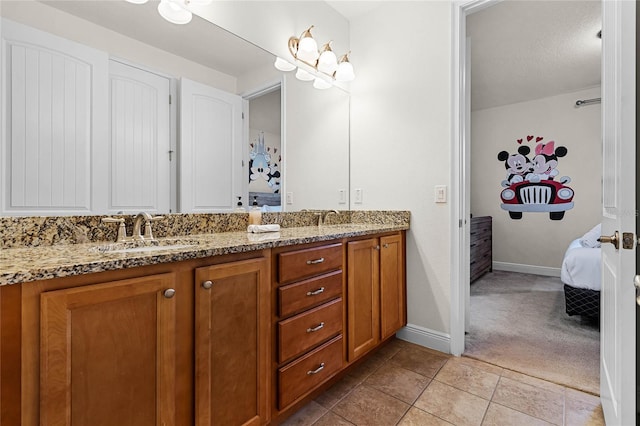 ensuite bathroom featuring double vanity, a sink, ensuite bath, baseboards, and tile patterned floors